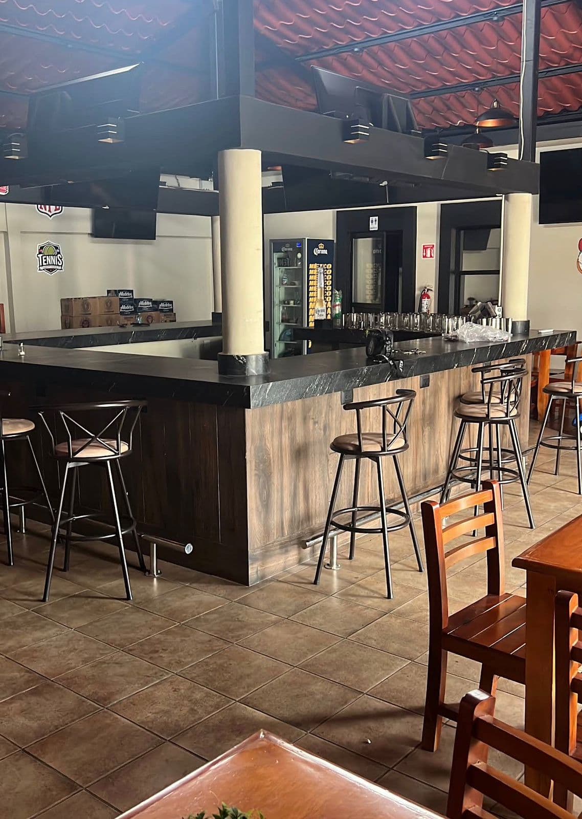 La barra del local con bancos altos y pantallas para los partidos